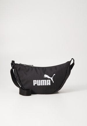Sort Puma bæltetaske med justerbar rem og hvidt Puma-logo foran mod en ensfarvet lys baggrund.