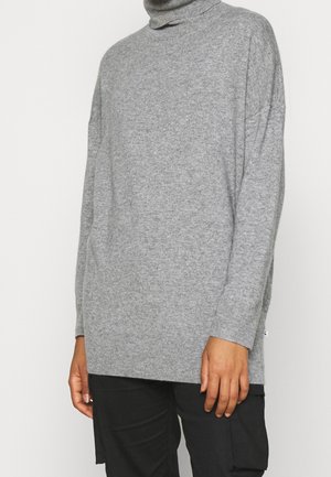 Grauer Rollkragenpullover mit lockerer Passform, weicher Textur und gerippten Bündchen. Verfügt über seitliche Schlitze für Bewegungsfreiheit und ein minimalistisches Design.