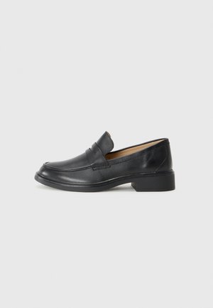Mocassins en cuir noir à surface lisse, bout arrondi, petit talon carré et coutures discrètes. Design classique, adapté aux tenues formelles.