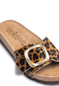 Luipaardprint slipper met een brede band, gouden metalen gesp, zachte suède voetbed en een gestructureerde kurken zool. Made in Spain.