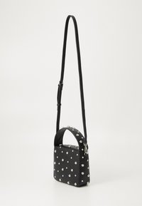 Černá obdélníková crossbody taška s nastavitelným popruhem a rukojetí, zdobená rozptýlenými stříbrnými cvočky na texturovaném povrchu.
