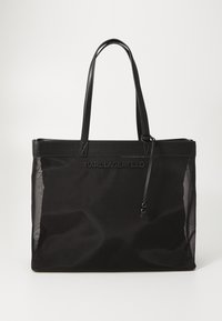 Black tote bag made of nylon with leather accents. Features handles, a drawstring closure, and a brand logo on the front. Textured mesh sides.