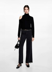 Črna off-shoulder turtleneck majica, črne hlače visokega pasu z širokimi nogavicami in studenčnim pasom ter črni dodatki. Gladke teksture, minimalističen dizajn.