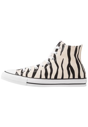 Højtop canvas sneaker med hvid bund og sorte zebra-striber, hvide snørrebånd og hvid gummisål med sort stribe.