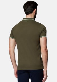 oliwkowa koszulka polo z miękkiego materiału, o klasycznym kroju, krótkich rękawach z kontrastowymi zielonymi paseczkami oraz małym logo na plecach.