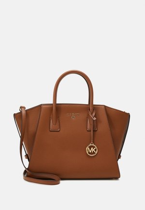 Sac à main en cuir marron avec double poignée supérieure, une bandoulière amovible et un charme en logo doré. Présente un design structuré et des coutures visibles.