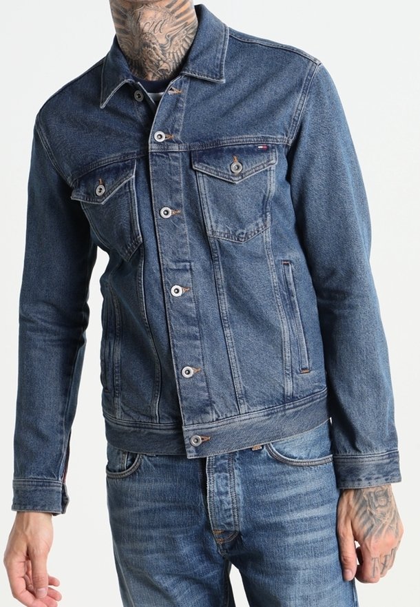 Tummansininen farkkutakki, jossa on klassinen kaulus, napitus, kaksi rintataskua ja istuva malli. Teksturoitu kangas, jossa on ompeluyksityiskohtia.