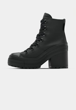 Schwarze High-Top-Stiefel aus strukturiertem Leder, mit runder Spitze, dickem Plateausohle und klobigem Absatz sowie Schnürung an der Vorderseite.