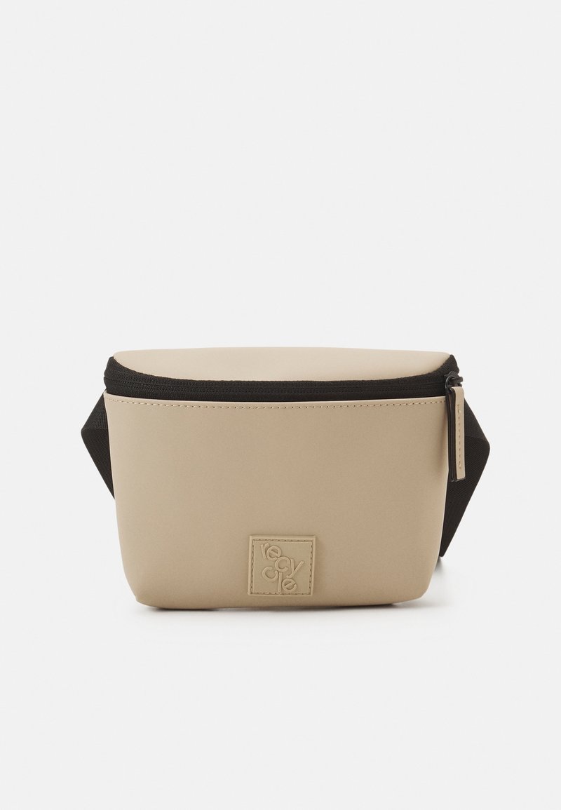 Pochette rectangulaire beige avec une texture lisse, fermeture éclair noire et une bandoulière detachable. Présente une petite patch logo à l'avant.