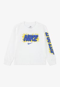 Weißes Baumwollhemd mit langen Ärmeln, das blaues "NIKE"-Textdesign mit gelben Spritzakzenten zeigt sowie zusätzlichem blauen Text auf dem rechten Ärmel.
