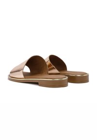 Sandalias deslizantes en un tono rosa dorado metálico, con punta abierta, textura suave, suela plana de goma marrón y un sutil detalle dorado en el borde de la suela.
