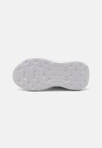 Semelle de sneaker blanche avec un design texturé comportant des creux rectangulaires et ovales pour l'adhérence et le soutien. Matériau en caoutchouc lisse.