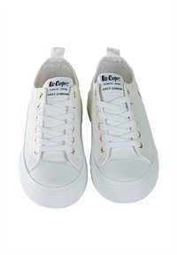 Białe płócienne trampki z złotymi oczkami, płaskimi sznurówkami i okrągłymi gumowymi noskami. Logo na języku, teksturowana gumowa podeszwa.