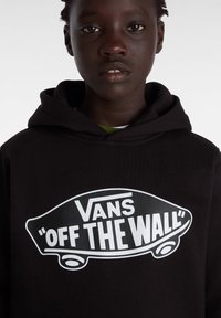 Felpa nera con cappuccio e logo grafico bianco che recita "VANS 'OFF THE WALL'", con un design di skateboard. Materiale in cotone, vestibilità comoda.