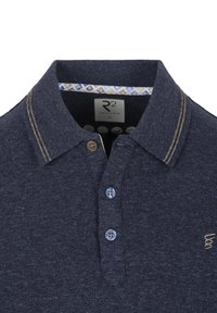 Navyblauwe polo gemaakt van textuurstof, met een klassieke kraag, twee knopen en contrasterende stiksels op de kraag.