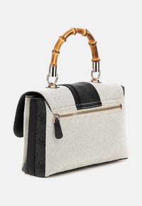 Sac à main blanc texturé avec des accents en cuir noir, poche extérieure zippée et poignées en bambou. Présente des accessoires en métal doré.