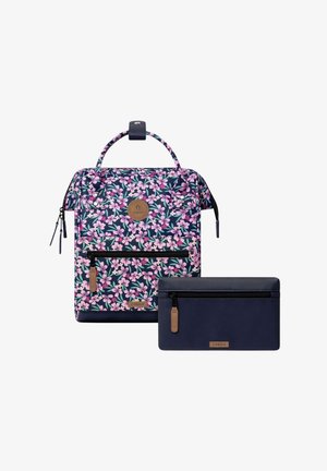 Rucksack mit Blumenmuster und pinken Blumen sowie einer Reißverschlusstasche vorne, kombiniert mit einer einfarbigen navyblauen Geldbörse mit Reißverschluss und Lederreißverschlussanhänger.