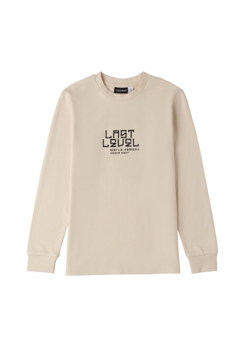 Maglietta a maniche lunghe beige in cotone con collo rotondo. Testo grafico nero centrato: "ULTIMO LIVELLO TOUR FEDELTÀ MONDIALE SKATE."