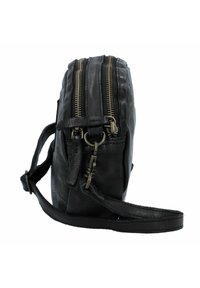 Bolso de cuero negro cruzado que presenta dos cremalleras de latón, una correa ajustable y detalles de costura sutiles en los bordes.