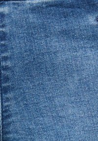 Denim w średnim niebieskim kolorze z teksturowanym splotem skośnym, z lekkim wyblaknięciem i gładkim wykończeniem.