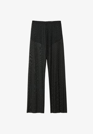 Pantaloni neri a gamba larga con piccoli pois bianchi, vita alta e una consistenza del tessuto liscia e leggermente lucida.