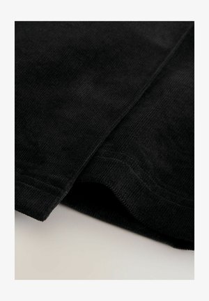 Zwarte corduroy stof met verticale ribbels, met een gladde textuur. De opgevouwen rand onthult een zachte binnenkant en nette stiksels.