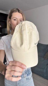 Boné de beje da Nike para beisebol com uma aba curva, apresentando um pequeno logotipo, seis painéis costurados e orifícios de ventilação. Textura de tecido suave.
