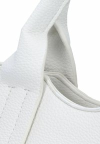 Sac en cuir blanc avec une surface texturée, des coutures saillantes et des bords lisses. Le design inclut deux poignées courbées pour un transport facile.