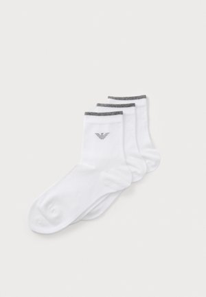 White cotton socks with short length, featuring gray striped ribbing at the top and a small printed logo on the outside of each sock.