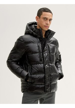 Chaqueta tipo puffer negra con un acabado brillante, diseño acolchado, capucha ajustable, cierre frontal con botones y múltiples bolsillos con cremallera.