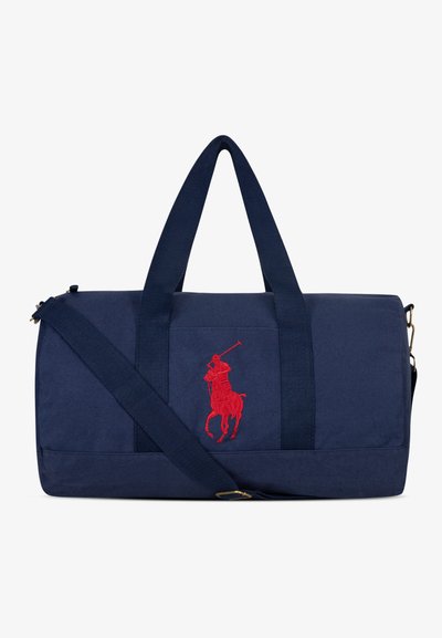 Bolsa de lona azul marino hecha de tela duradera, con dos asas superiores, una correa de hombro ajustable y un prominente bordado del logo de polo en rojo.