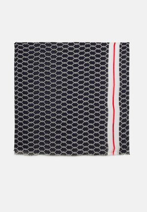 Tissu bleu foncé avec un motif de nœud de corde blanc et des rayures parallèles blanches et rouges le long d'un bord, plié sur un fond blanc.