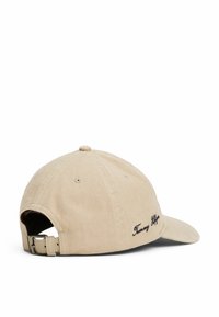 Gorra de béisbol de algodón beige con visera curved, logotipo bordado en negro y una pestaña ajustable con un hebilla de metal en la parte de atrás.
