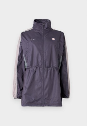 Veste coupe-vent violette avec accents gris, col montant, taille élastique et manches longues. Comprend un petit logo sur la poitrine.