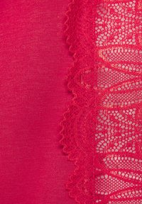 Crvena tkanina glatke teksture, s kompliciranom crvenom čipkom s jedne strane, koja ima valoviti rub i cvjetni uzorak.