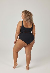 Czarny dwuczęściowy kostium kąpielowy z górą o zaokrąglonym dekolcie i majtkami z wysokim stanem. Gładka tkanina, minimalna ilość szwów, brak widocznych wzorów lub elementów metalowych.