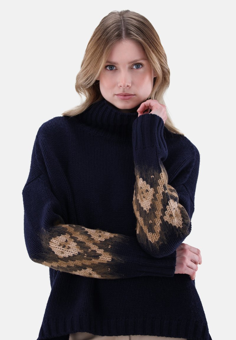 Navy gestrickter Pullover mit hohem Rollkragen und gemusterten braunen Ärmeln mit Herzmotiven, der ein gemütliches, strukturiertes Design präsentiert.