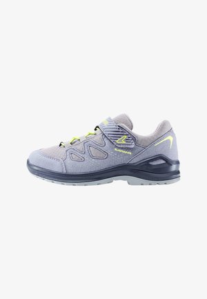 Scarpa da ginnastica grigio chiaro con dettagli in giallo neon, cinturino in velcro e suola nera, progettata per uso all'aperto o casual.