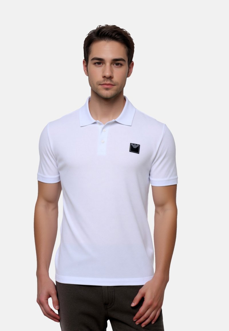 Weißes Poloshirt aus Baumwolle mit einem schwarzen Logo-Patch auf der Brust, kurzen Ärmeln und klassischem Kragen.