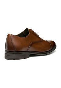 Scarpa da uomo in pelle marrone con una finitura liscia, punta rotonda e suola in gomma bassa e rigata. Presenta un design con lacci e dettagli di cucitura sottili.