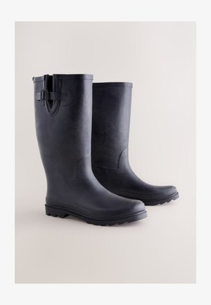 Czarne gumowe buty o gładkim wykończeniu, zaokrąglonym nosku, fakturowanej podeszwie i regulowanym pasku na górze zapewniającym pewne dopasowanie.