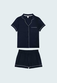 Conjunto de pijama de manga corta en navy con ribete blanco. La parte superior abotonada cuenta con un bolsillo en el pecho; los pantalones cortos tienen una cinturilla elástica y ribete en el dobladillo.