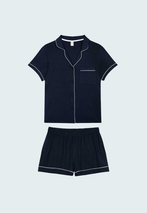 Marineblauw pyjama set met korte mouwen en witte bies. Het knoopsluiting shirt heeft een borstzak; de shorts hebben een elastische tailleband en hem bies.