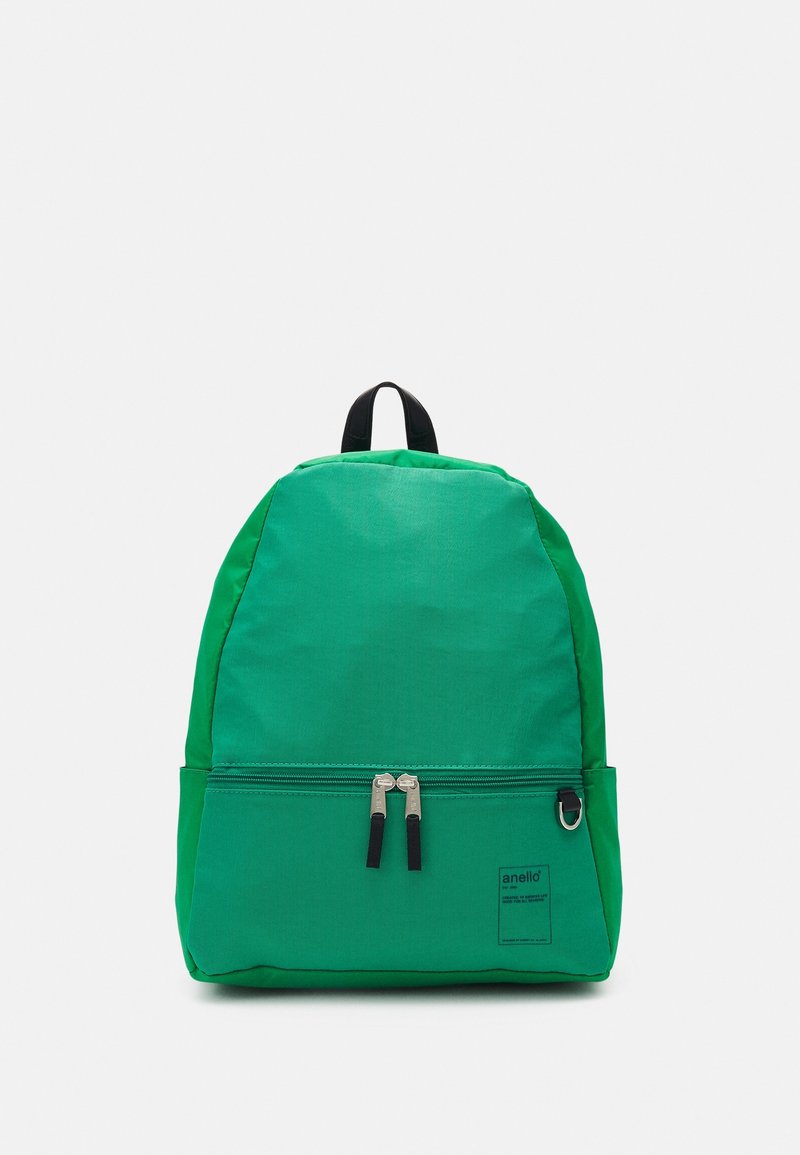 Grøn rygsæk lavet af holdbart stof med en rund form, dobbelt lynlåslukning og en lynlåslomme foran. Sorte detaljer på lynlåse.