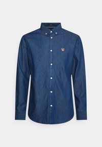 Camicia in denim blu scuro a maniche lunghe con bottoni bianchi, colletto a punta e piccolo logo a scudo rosso e bianco sul lato sinistro del petto.