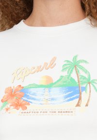 Wit katoenen T-shirt met een kleurrijke afbeelding van een zonsondergang, zee, palmbomen en hibiscusbloemen, met het label "Ripcurl" en een slogan eronder.