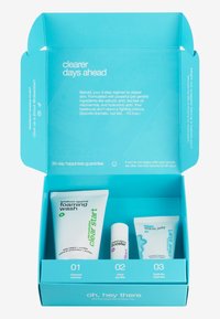 Boîte en bleu vif contenant trois produits de soin de la peau : nettoyant moussant, activateur et gelée aqua, tous avec des étiquettes claires et un design moderne.