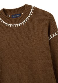Brauner Strickpullover mit Rundhalsausschnitt und weißen Dekostichen, strukturierter Oberfläche und lockerer Passform. Markenlabel sichtbar.