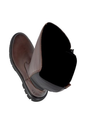 Botte en cuir marron unique avec panneau latéral élastique noir et semelle en caoutchouc noir épaisse, vue de dessus et de côté en angle sur fond blanc.