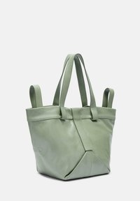 Zielona skórzana torba tote o zdefiniowanym kształcie, z dwoma krótkimi uchwytami i złożonym wzorem. Gładka tekstura z widocznym szyciem.